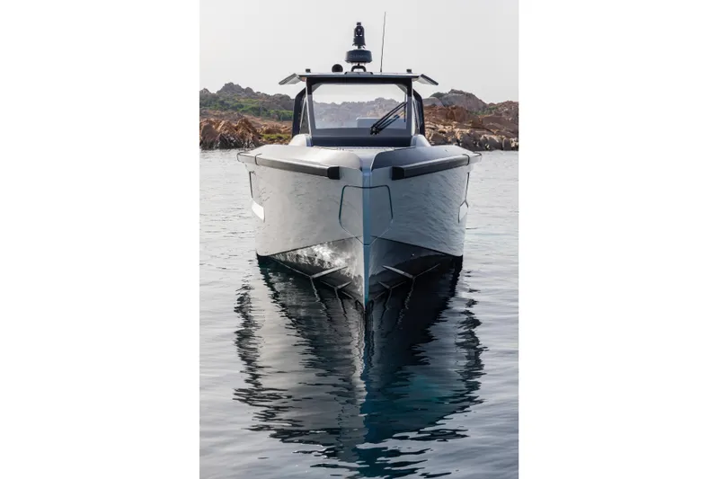  Yacht Photos Pics Maori 46 Outboard 2026 on calm water near rocky coastline.