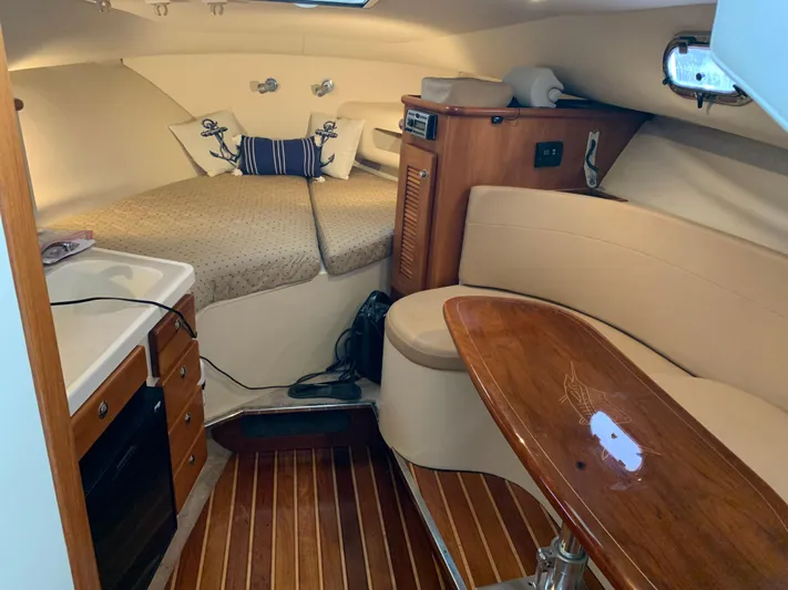  Yacht Photos Pics 2007 Pursuit OS 335 cabin interior with cozy seating and wooden table.