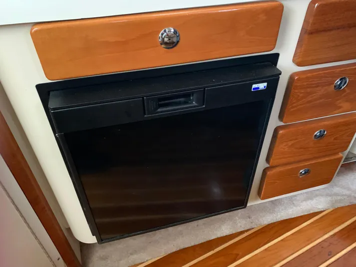  Yacht Photos Pics 2007 Pursuit OS 335 interior with wooden cabinetry and built-in black refrigerator.