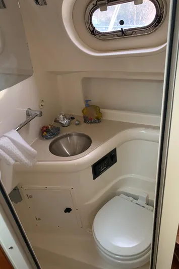  Yacht Photos Pics 2007 Pursuit OS 335 boat bathroom with sink, toilet, and porthole window.