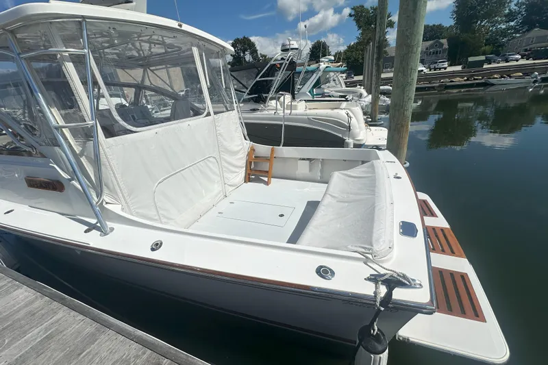 At Last 10 Yacht Photos Pics 2017 Fortier F-30 Hardtop boat docked at marina, featuring spacious deck and clear canopy.