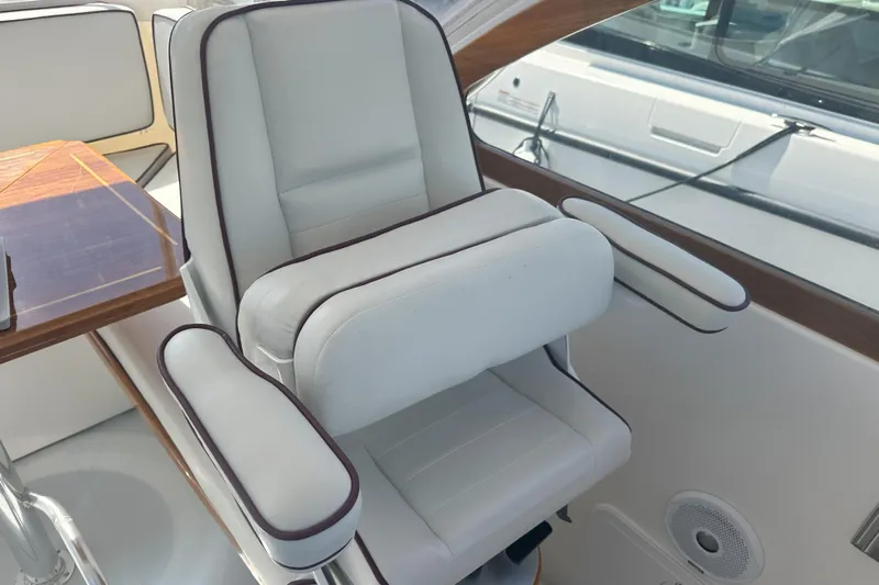 At Last 10 Yacht Photos Pics Luxurious seating in 2017 Fortier F-30 Hardtop boat interior, featuring white upholstery and wooden accents.