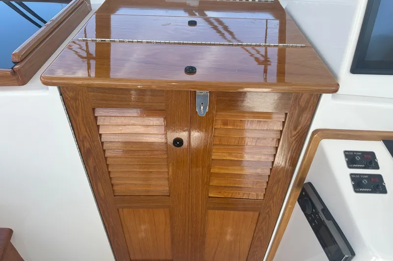 At Last 10 Yacht Photos Pics Wooden cabinet on 2017 Fortier F-30 Hardtop boat, featuring polished finish and control panels.