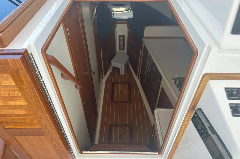 At Last 10 Yacht Photos Pics Interior view of 2017 Fortier F-30 Hardtop boat with wooden finishes and compact layout.