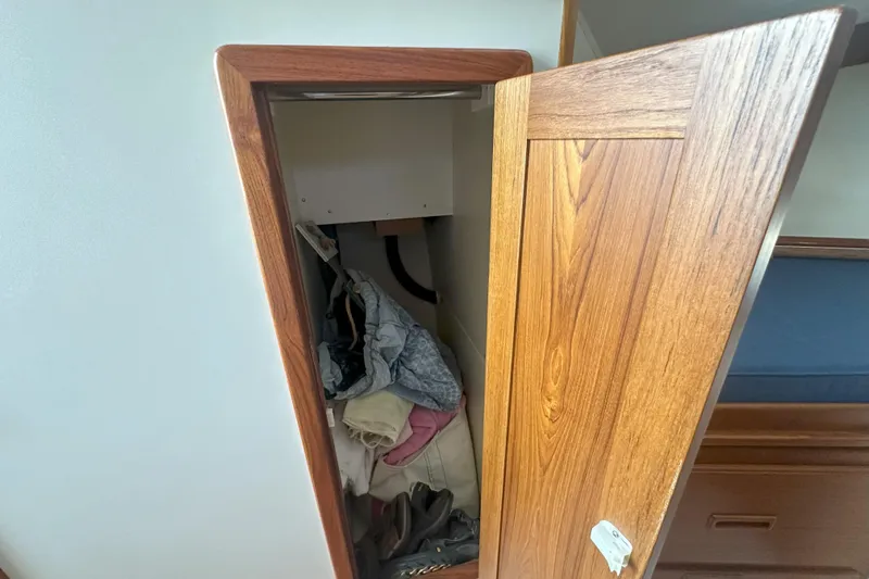 At Last 10 Yacht Photos Pics Wooden cabinet with open door on 2017 Fortier F-30 Hardtop boat, revealing stored items.