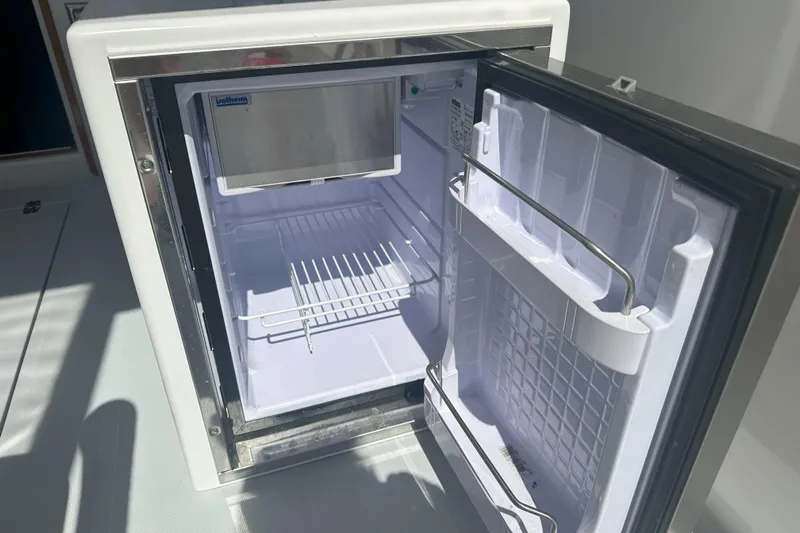 At Last 10 Yacht Photos Pics Open refrigerator on 2017 Fortier F-30 Hardtop boat, showing interior shelves and door compartments.