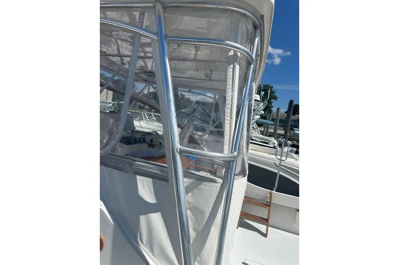 At Last 10 Yacht Photos Pics 2017 Fortier F-30 Hardtop boat with clear enclosure and metal framework.