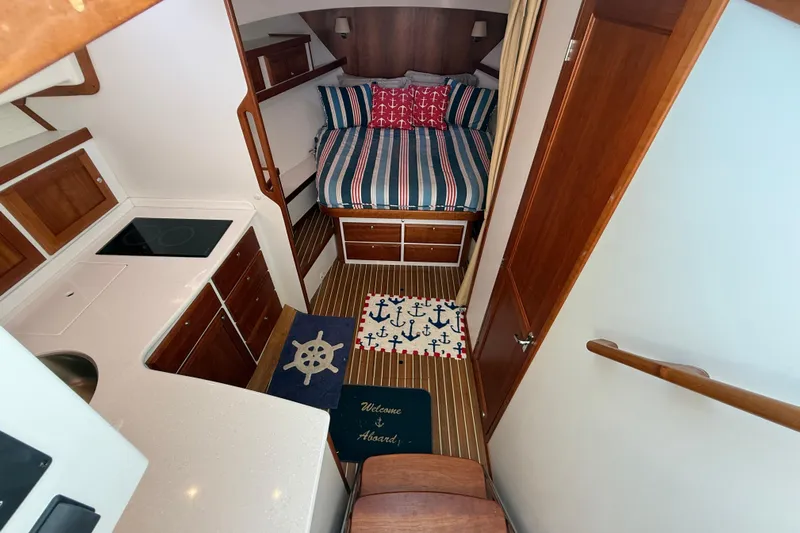 Never Say Never Again Yacht Photos Pics 2019 Back Cove Downeast 37 interior with cozy bed, kitchenette, and nautical decor.