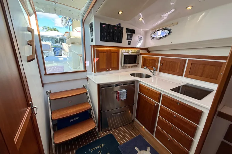 Never Say Never Again Yacht Photos Pics 2019 Back Cove Downeast 37 yacht interior with modern kitchen and wooden cabinetry.