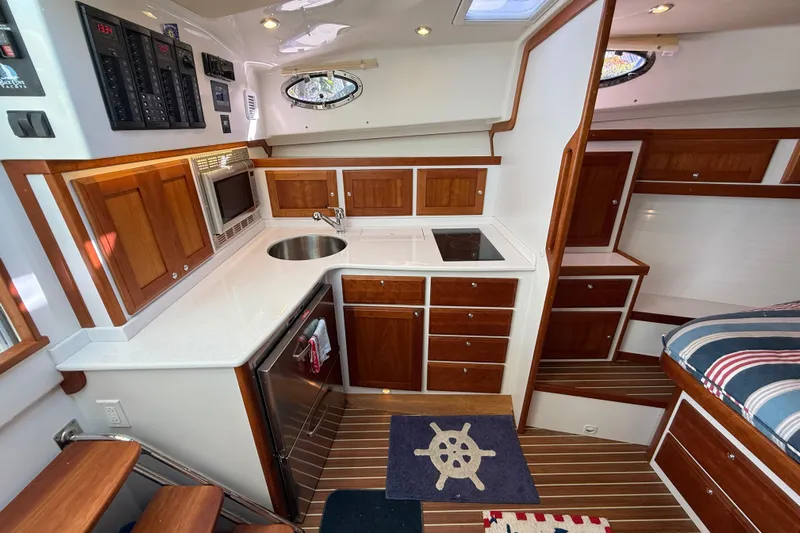 Never Say Never Again Yacht Photos Pics 2019 Back Cove Downeast 37 interior with wooden cabinetry, compact kitchen, and nautical decor.