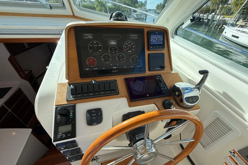 Never Say Never Again Yacht Photos Pics 2019 Back Cove Downeast 37 helm with modern navigation instruments and wooden steering wheel.