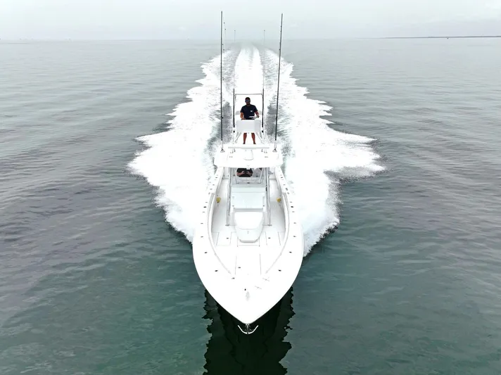  Yacht Photos Pics 2023 Contender 39 ST boat cruising on calm water, aerial view.