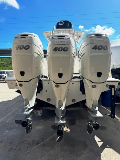  Yacht Photos Pics 2023 Contender 39 ST boat with triple 400 horsepower engines, docked under a clear blue sky.