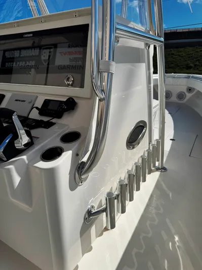  Yacht Photos Pics 2023 Contender 39 ST boat console with controls and rod holders under clear blue sky.