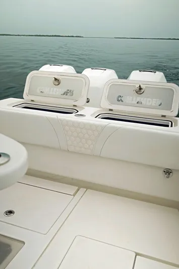  Yacht Photos Pics 2023 Contender 39 ST boat with open storage compartments on calm water.