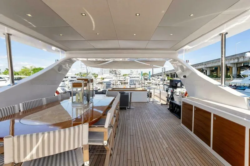  Yacht Photos Pics Luxurious 2006 Tecnomar 35 Nadara yacht deck with elegant dining area and marina view.