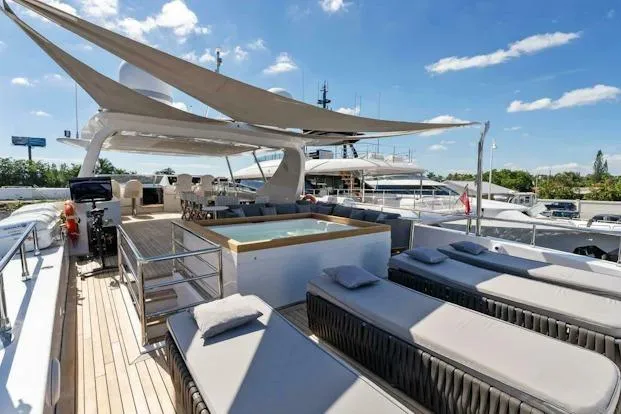  Yacht Photos Pics Luxurious 2006 Tecnomar 35 Nadara yacht deck with sun loungers and jacuzzi under a clear sky.