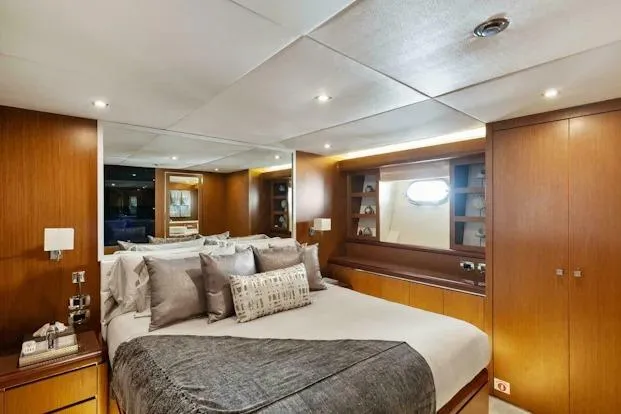  Yacht Photos Pics Luxurious bedroom interior on 2006 Tecnomar 35 Nadara yacht, featuring elegant wood paneling.