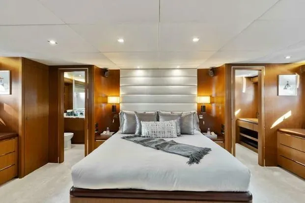  Yacht Photos Pics Luxurious bedroom interior on 2006 Tecnomar 35 Nadara yacht, featuring elegant wood finishes.