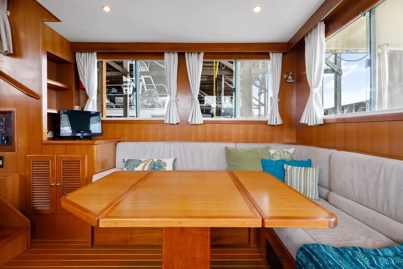 Greymalkin II Yacht Photos Pics Interior of 2008 North Pacific 39 Pilothouse with wooden table and cozy seating.