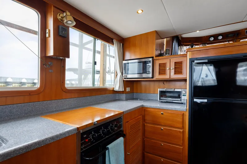 Greymalkin II Yacht Photos Pics 2008 North Pacific 39 Pilothouse kitchen with wood cabinetry, appliances, and large windows.