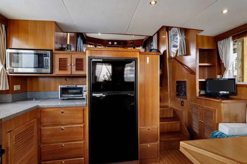 Greymalkin II Yacht Photos Pics Interior of 2008 North Pacific 39 Pilothouse with kitchen and wooden cabinetry.