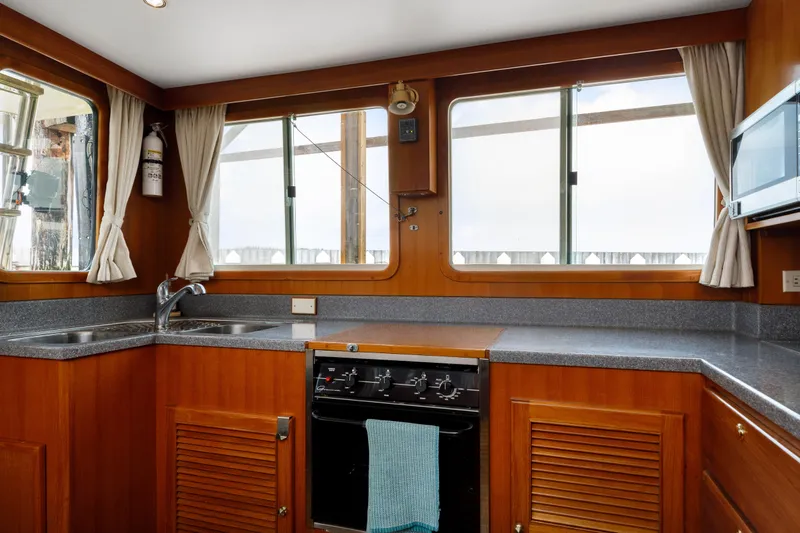 Greymalkin II Yacht Photos Pics Interior of 2008 North Pacific 39 Pilothouse kitchen with wood cabinetry and appliances.