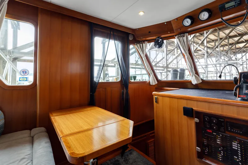 Greymalkin II Yacht Photos Pics 2008 North Pacific 39 Pilothouse interior with wood paneling, table, and control panel.