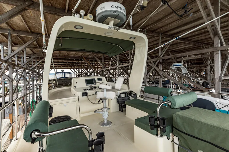 Greymalkin II Yacht Photos Pics 2008 North Pacific 39 Pilothouse boat interior with green seating and navigation equipment.