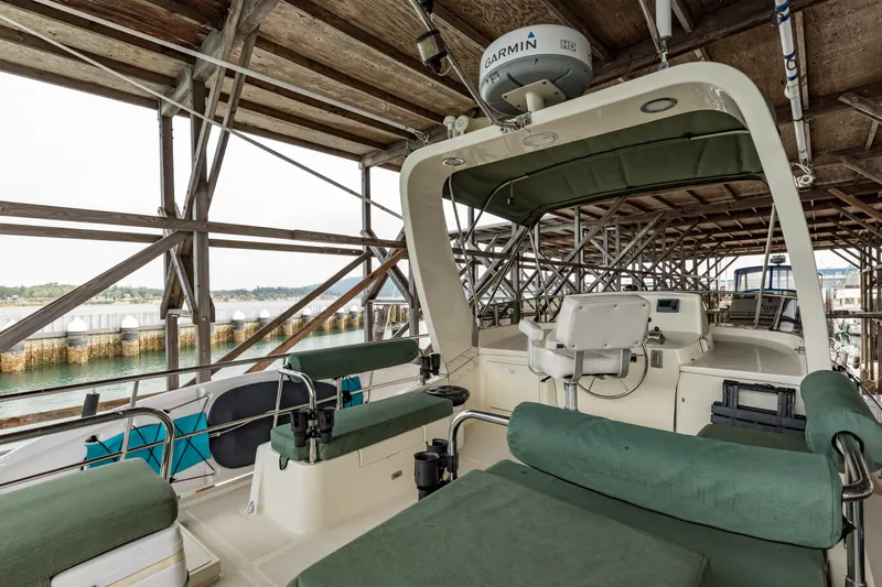 Greymalkin II Yacht Photos Pics 2008 North Pacific 39 Pilothouse boat interior with green seating under a wooden dock.