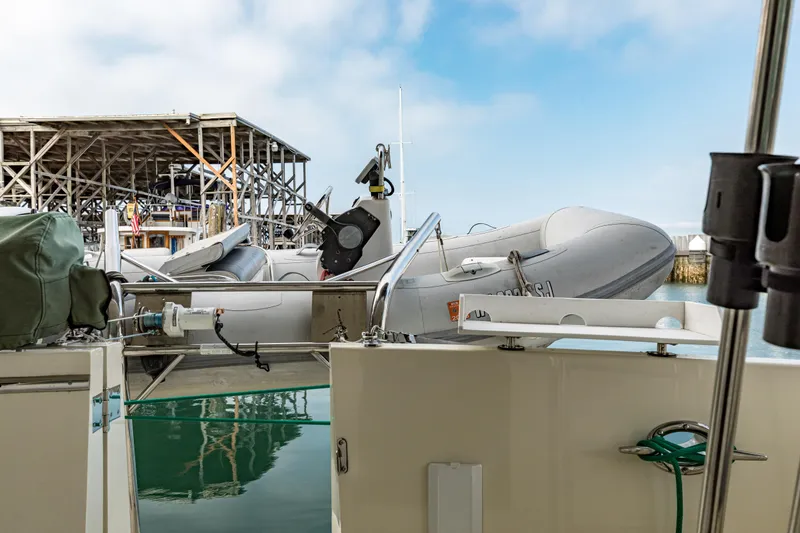 Greymalkin II Yacht Photos Pics 2008 North Pacific 39 Pilothouse with dinghy at dockside, clear sky background.