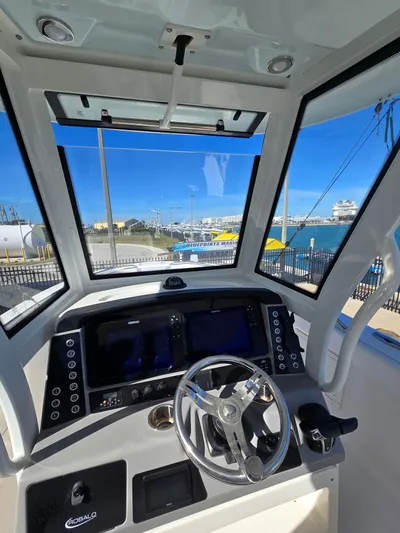No Regrets Yacht Photos Pics Interior view of 2022 Robalo R272 helm with ocean view.