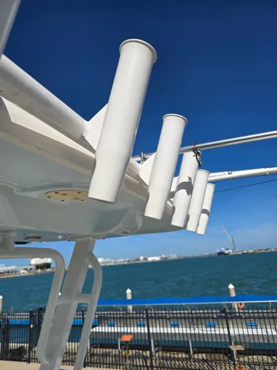 No Regrets Yacht Photos Pics Robalo R272 Center Console 2022 with fishing rod holders by the water.