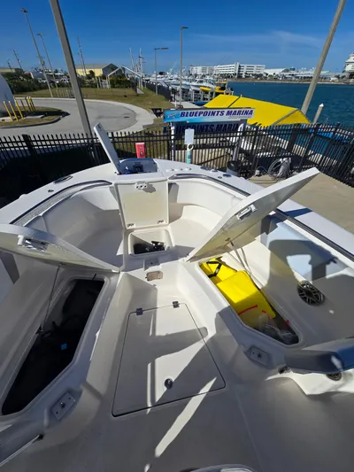 No Regrets Yacht Photos Pics 2022 Robalo R272 Center Console at marina, open storage compartments visible.