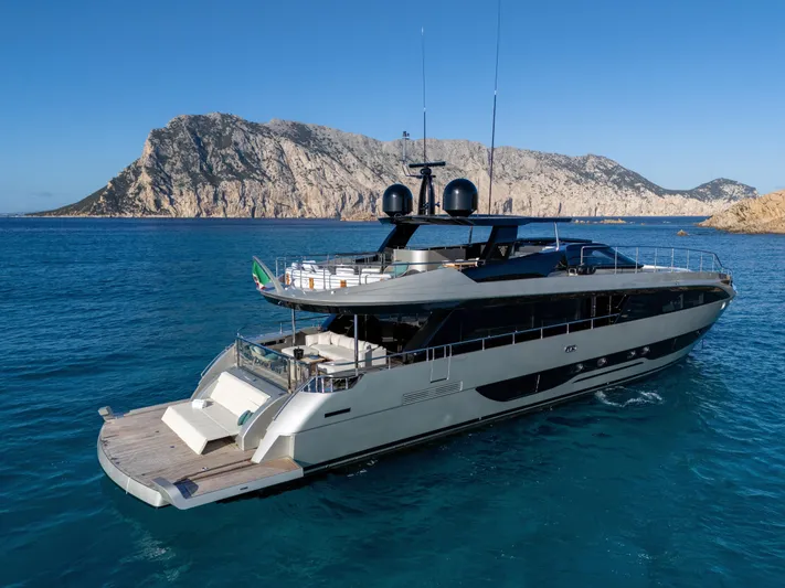 Filippetti F100 Yacht Photos Pics Luxurious 2026 Filippetti F100 yacht cruising in clear blue waters near rocky coastline.