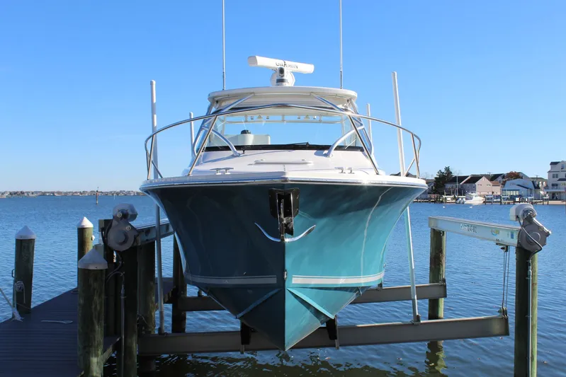 Mary Michele Yacht Photos Pics 2022 Albemarle 30 Express boat docked on a lift, with a scenic waterfront backdrop.