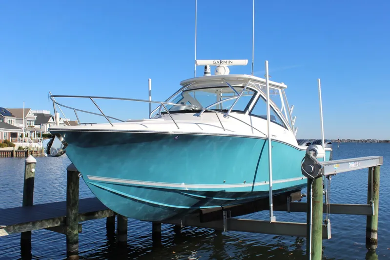 Mary Michele Yacht Photos Pics 2022 Albemarle 30 Express boat docked on a lift, with a clear blue sky.