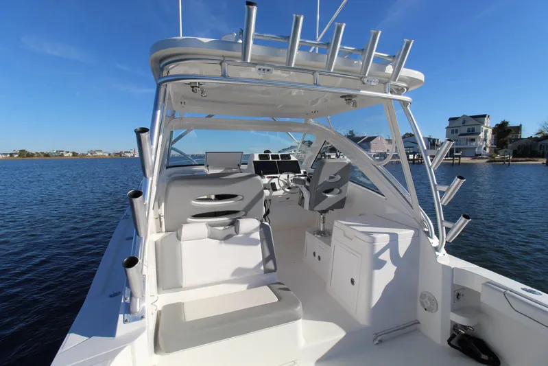 Mary Michele Yacht Photos Pics 2022 Albemarle 30 Express boat interior with seating and helm, docked on calm water.