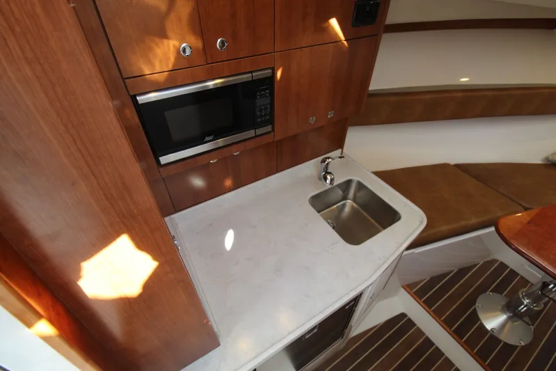 Mary Michele Yacht Photos Pics 2022 Albemarle 30 Express cabin with kitchenette, featuring a microwave, sink, and seating area.