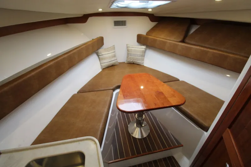 Mary Michele Yacht Photos Pics 2022 Albemarle 30 Express cabin interior with brown seating and wooden table.