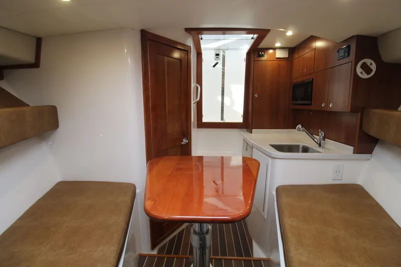 Mary Michele Yacht Photos Pics Interior of 2022 Albemarle 30 Express boat with seating, table, and kitchenette.