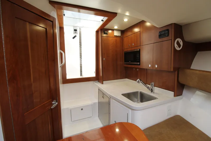 Mary Michele Yacht Photos Pics 2022 Albemarle 30 Express boat interior with modern kitchenette and wooden cabinetry.
