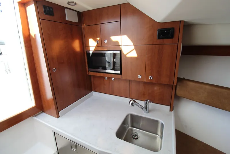 Mary Michele Yacht Photos Pics 2022 Albemarle 30 Express boat interior with wooden cabinetry and stainless steel sink.