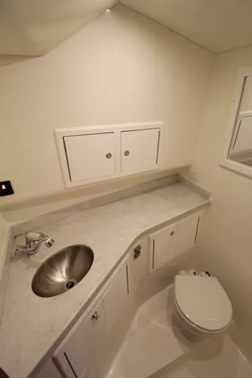 Mary Michele Yacht Photos Pics 2022 Albemarle 30 Express boat bathroom with sink, toilet, and storage cabinets.