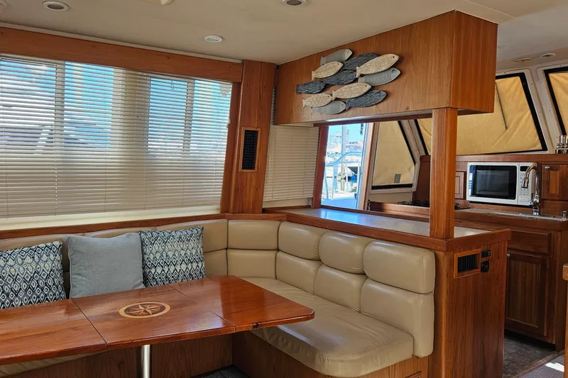  Yacht Photos Pics Interior of 1999 Mainship 430 Trawler with cozy seating and wooden accents.
