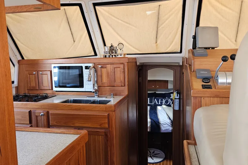  Yacht Photos Pics Interior of 1999 Mainship 430 Trawler with kitchen and cozy cabin view.