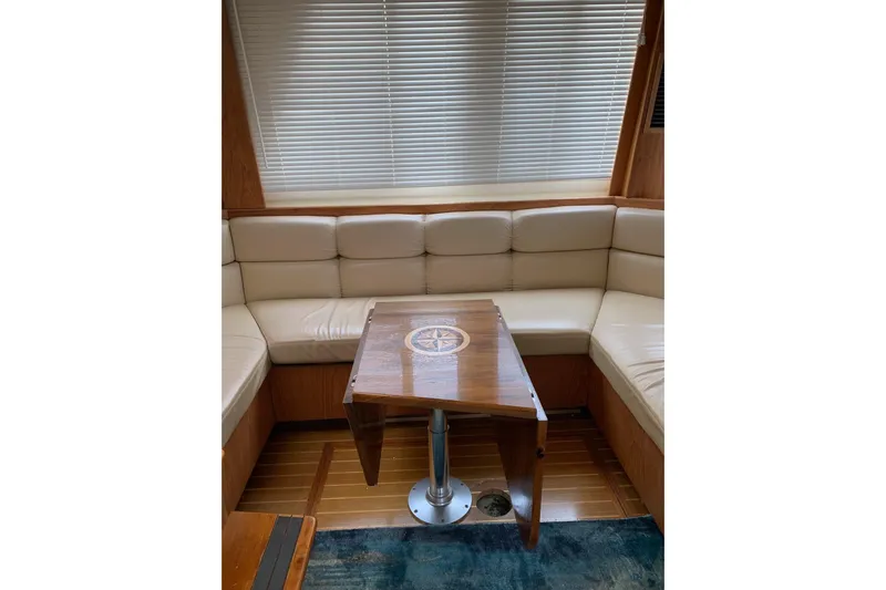  Yacht Photos Pics Interior of 1999 Mainship 430 Trawler with beige seating and wooden table.