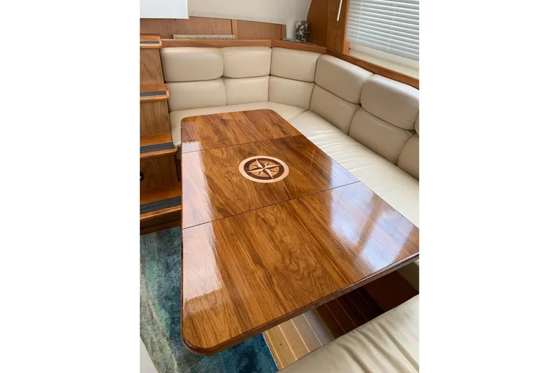  Yacht Photos Pics Luxurious interior of 1999 Mainship 430 Trawler with elegant wood table and plush seating.