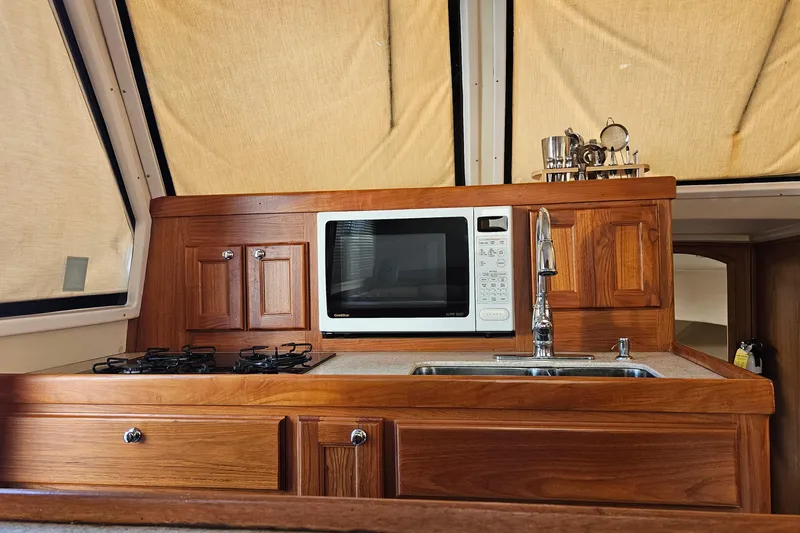 Yacht Photos Pics 1999 Mainship 430 Trawler kitchen with microwave, stove, and sink.