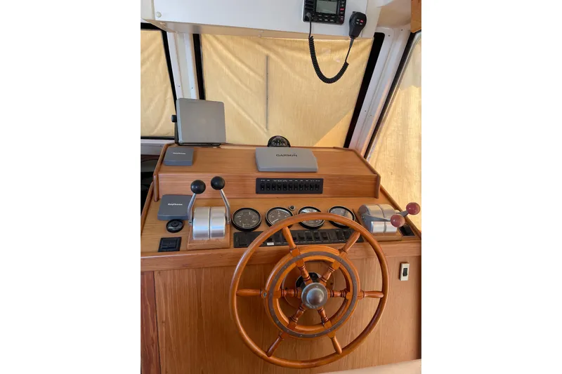  Yacht Photos Pics 1999 Mainship 430 Trawler helm with wooden wheel and navigation instruments.